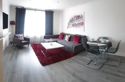 a living room with a couch and a red rug at Vkm Apartments in Glasgow