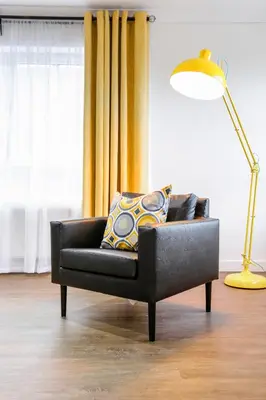 a black couch sitting in a living room with a lamp at Vkm Apartments in Glasgow