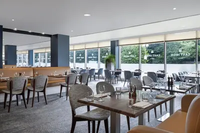 a restaurant with tables and chairs and windows at Delta Hotels by Marriott Edinburgh in Edinburgh