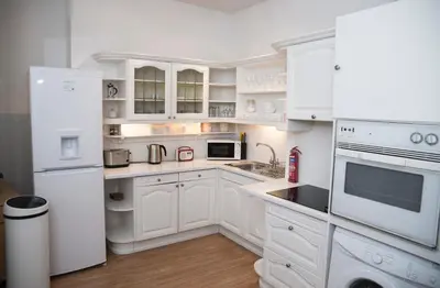 a white kitchen with white appliances and white cabinets at Edinburgh, Stockbridge Apartment in Edinburgh