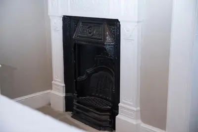 a black fireplace in a corner of a room at Edinburgh, Stockbridge Apartment in Edinburgh