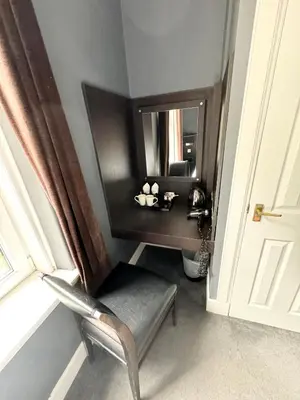 a room with a mirror and a chair and a chair sidx sidx sidx at Murrayfield Park Guest House in Edinburgh