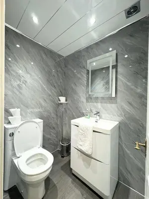 a bathroom with a toilet and a sink and a mirror at Murrayfield Park Guest House in Edinburgh