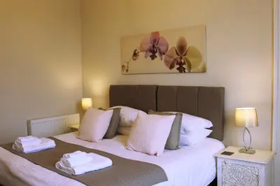 a bedroom with a bed with two towels on it at Kirk View Apartment in Stirling
