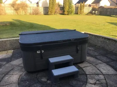 a trash can sitting on the ground in a yard at Pippin, Tranquil Scottish Cottage with Hot Tub in Airdrie
