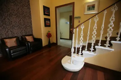 a living room with a staircase and two chairs at Acorn Hotel in Glasgow