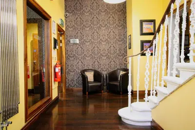 a hallway with two black chairs and a fire extinguisher at Acorn Hotel in Glasgow