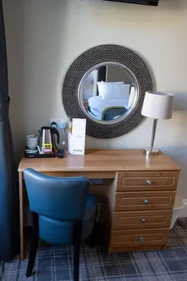 a desk with a blue chair and a mirror at The Waverley Hotel in Callander