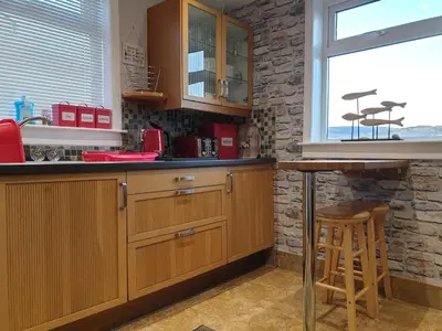 a kitchen with wooden cabinets and a counter top at Tigh Na Mara in Furnace
