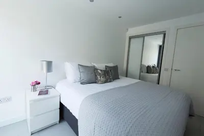 a white bedroom with a large bed and a mirror at Gillespie House in Edinburgh
