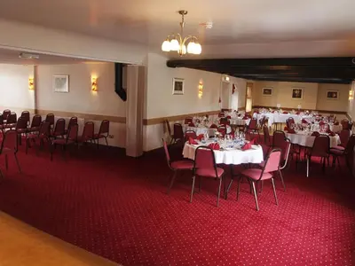 a dining room with tables and chairs and a room with at Elphinstone Hotel in Biggar