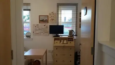 a room with a desk and a television on a dresser at BroomHouse HomeStay in Edinburgh