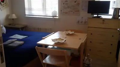 a room with a desk and a table and a bed at BroomHouse HomeStay in Edinburgh