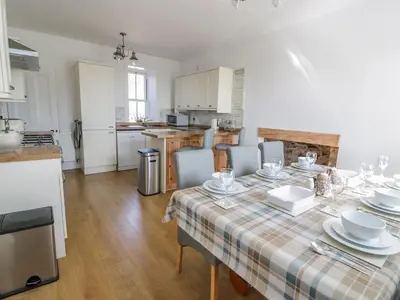 a kitchen with a table with plates and glasses on it at Corrafeckloch Forest Cottages in Bargrennan