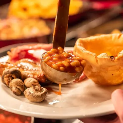 a plate of food with a spoon with beans in it at Toby Carvery Edinburgh West by Innkeeper's Collection in Edinburgh