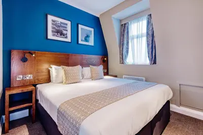 a bedroom with a large bed and a blue wall at Toby Carvery Edinburgh West by Innkeeper's Collection in Edinburgh