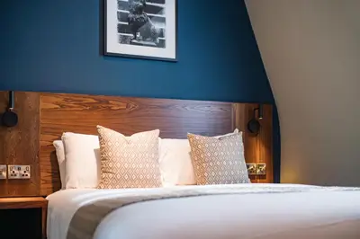 a bedroom with a large bed with a blue wall at Toby Carvery Edinburgh West by Innkeeper's Collection in Edinburgh