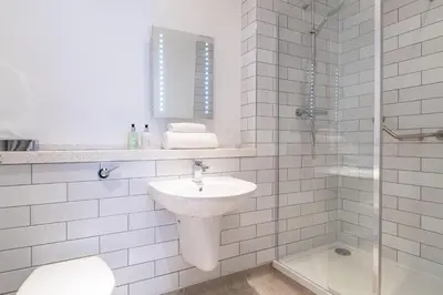 a white bathroom with a sink and a shower at The Hawes Inn by Innkeeper's Collection in Queensferry