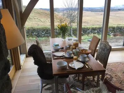 a dining room with a table and a large window at Winterton in Lochgilphead