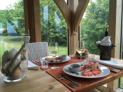 a table with two plates of food and glasses of wine at Winterton in Lochgilphead