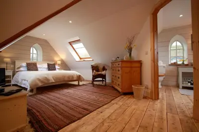 a bedroom with a bed and a dresser and windows at Winterton in Lochgilphead