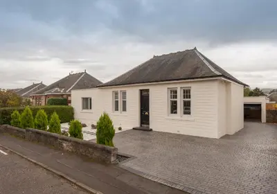 a white house with a black roof on a driveway at The Traquair Park Residence in Edinburgh