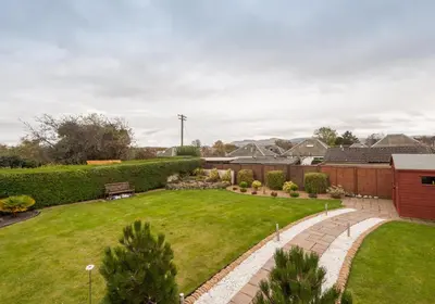 a backyard with a lawn and landscaping at The Traquair Park Residence in Edinburgh