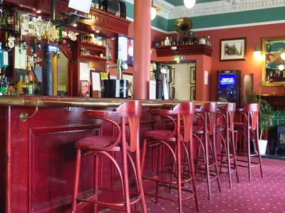 a row of red stools at a bar at Ardmillan Hotel in Edinburgh