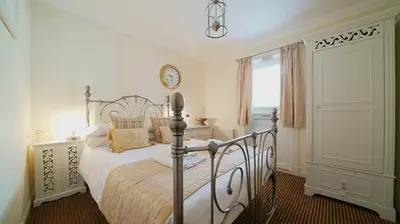 a bedroom with a bed and a clock on the wall at The Old Tramhouse Self Catering Apartments in Stirling