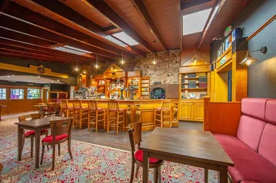a restaurant with a bar and tables and chairs at The Galley Of Lorne Inn in Ardfern