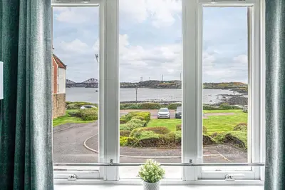 a window with a view of a body of water at Super Prime Luxury Waterfront View DBay by TBA in Saint Davids