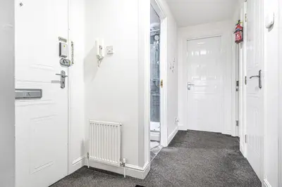 a hallway with white walls and white doors at Super Prime Luxury Waterfront View DBay by TBA in Saint Davids