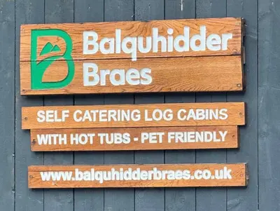 a sign on the side of a building at Balquhidder Braes Holiday Park Lodges, mostly with Hot Tubs and pet friendly, EV facilities in Lochearnhead