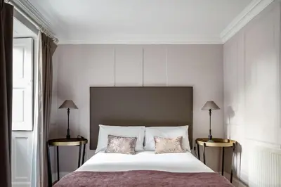 a bedroom with a large white bed with two lamps at Drylaw House, Grade A Listed Mansion near City Centre in Edinburgh