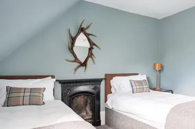 a bedroom with two beds and a fireplace at Drylaw House, Grade A Listed Mansion near City Centre in Edinburgh