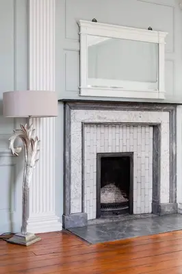 a living room with a fireplace with a mirror at Drylaw House, Grade A Listed Mansion near City Centre in Edinburgh
