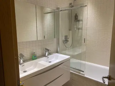 a white bathroom with a sink and a shower at 2 bed Chic Apartment in Glasgow City Centre in Glasgow