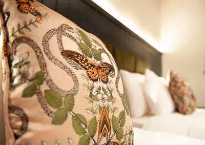 a blanket with butterflies on it sitting on a bed at The Coachman Hotel in Kilsyth