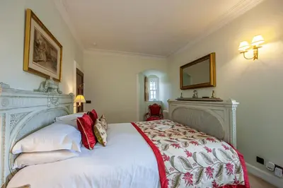 a bedroom with a large white bed and a mirror at Barcaldine Castle in Oban