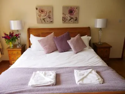 a bedroom with a bed with two towels on it at Shore House in Tarbet