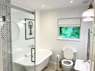 a bathroom with a tub and a toilet and a sink at Shore House in Tarbet