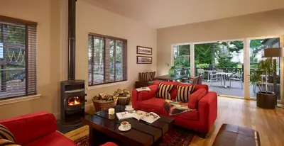 a living room with a red couch and a fireplace at Wyndham Duchally Country Estate in Auchterarder