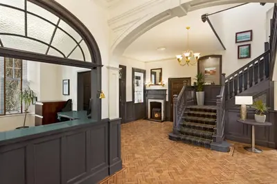 a lobby with a staircase and a stair case at Wyndham Duchally Country Estate in Auchterarder