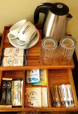 a wooden book shelf with a tea pot and books at Dungallan Country House in Oban