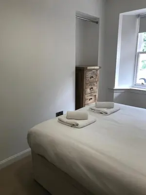 a bedroom with a large bed with two pillows on it at Trinity Lodge - Home with Private Garden and Parking in Edinburgh
