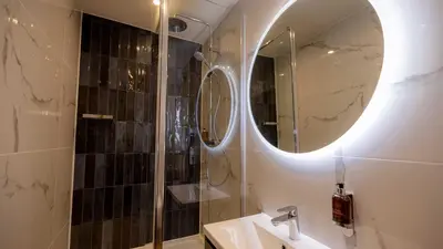 a bathroom with a shower and a sink and a mirror at Brisbane House Hotel in Largs