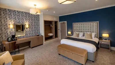 a large bedroom with a large bed and a desk at Brisbane House Hotel in Largs