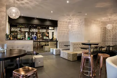 a restaurant with a bar with tables and stools at Avonbridge Hotel in Hamilton
