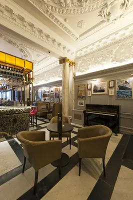 a lobby with tables and chairs and a piano at Native Glasgow in Glasgow
