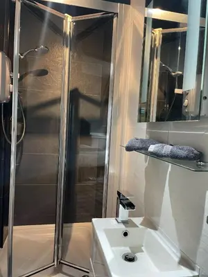 a bathroom with a shower and a sink at Gowanlea Guest House in Balloch